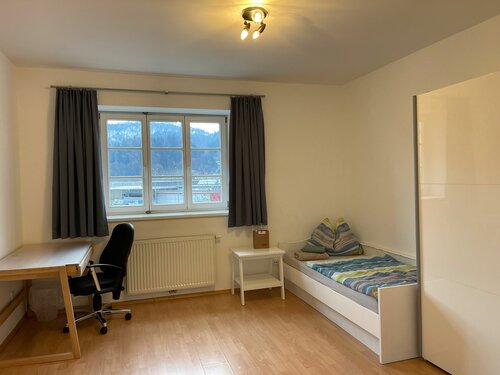 kleines Zimmer mit Tisch und Bett